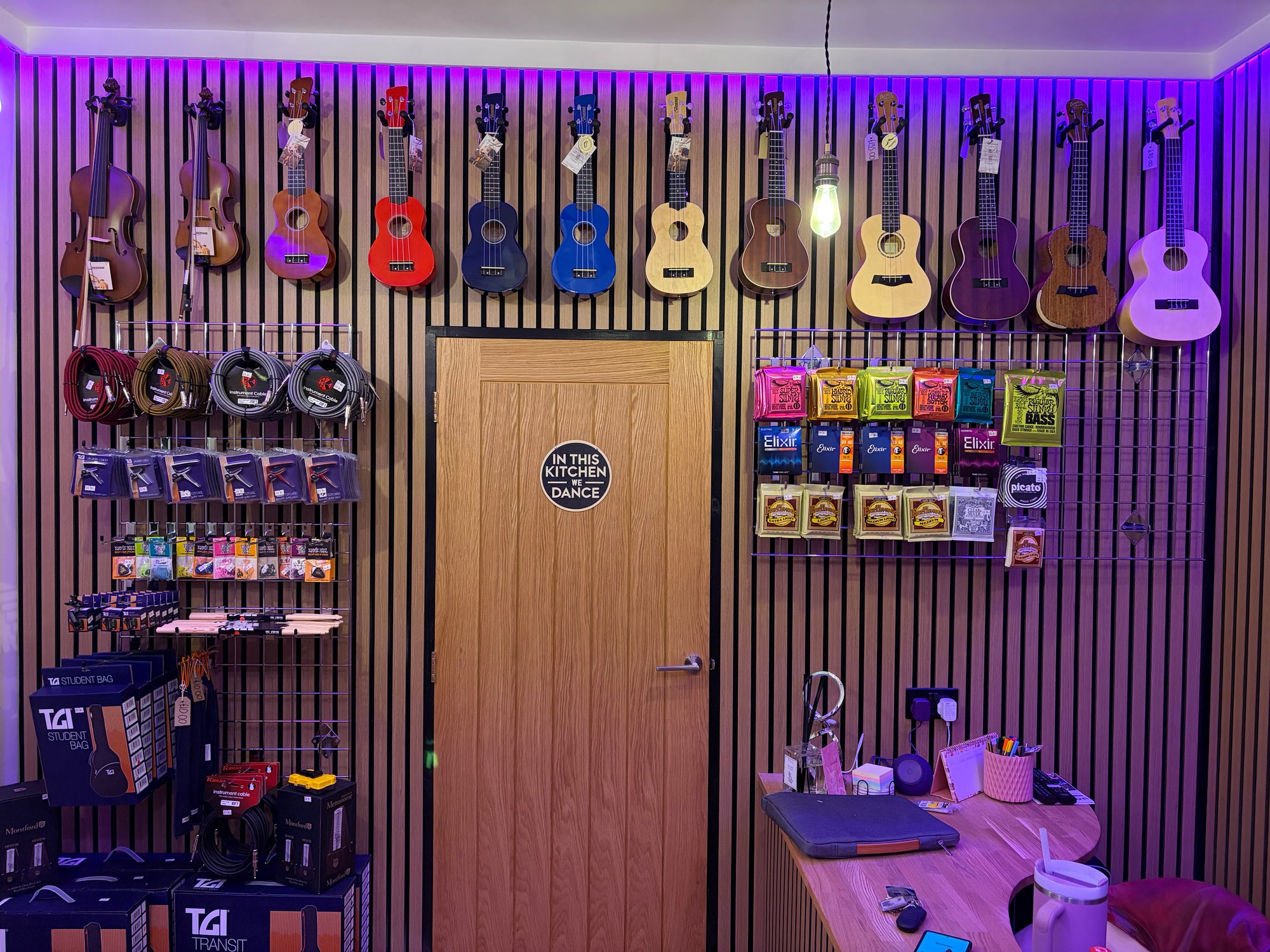 Music store interior with guitars on the wall and merchandise below.