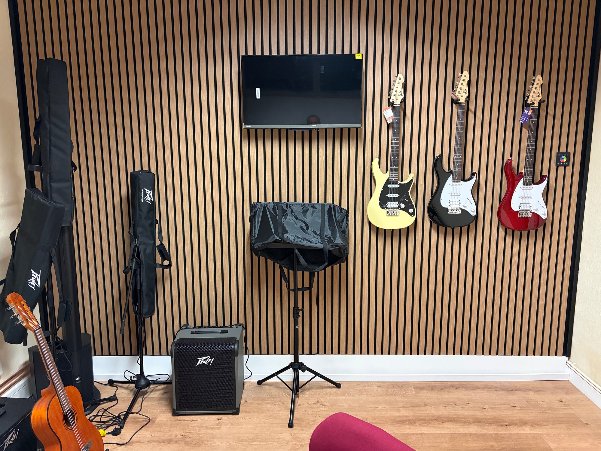 Music room with guitars on the wall, amplifier, and musical equipment.
